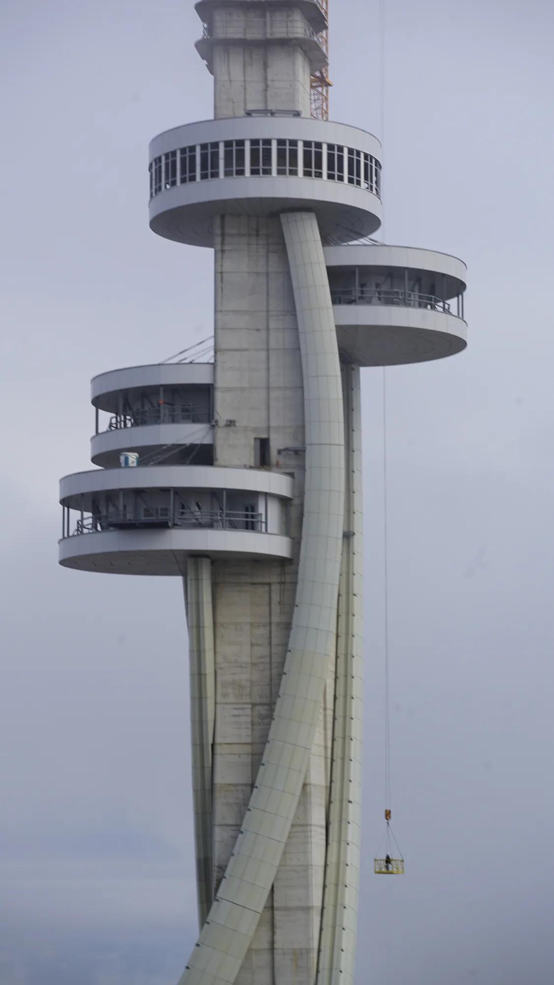 Concrete tower with circular platforms and a suspended construction basket