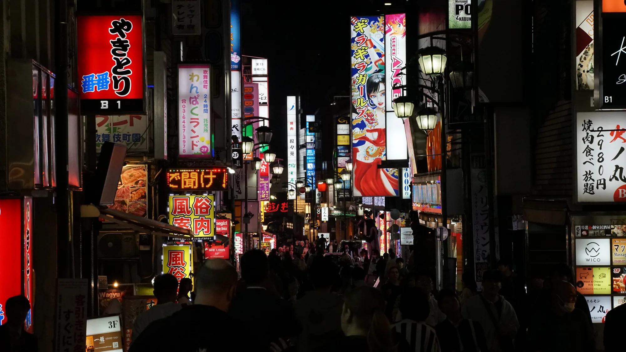 Busy street in Kabukicho filled with Japanese illuminated signs at night